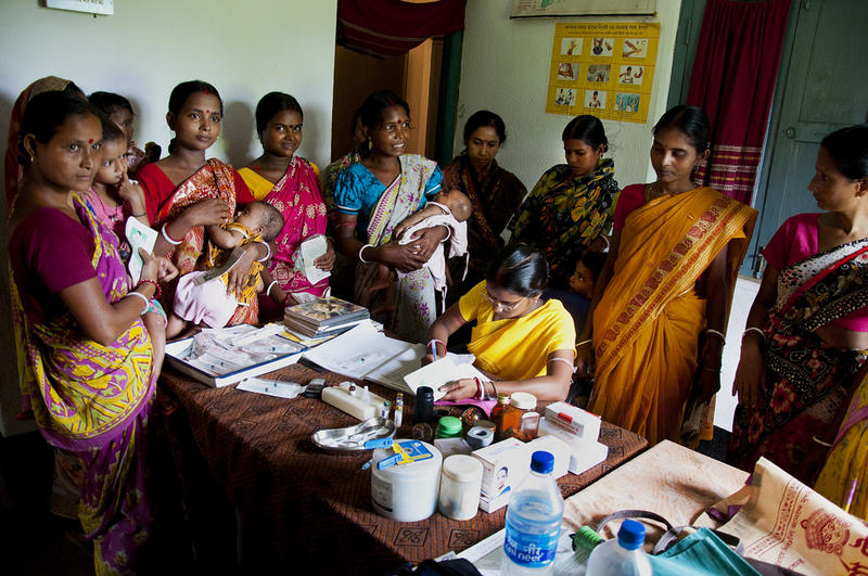 Family Planning and Immunization Integration Women with babies around a desk with a nurse filling out documents