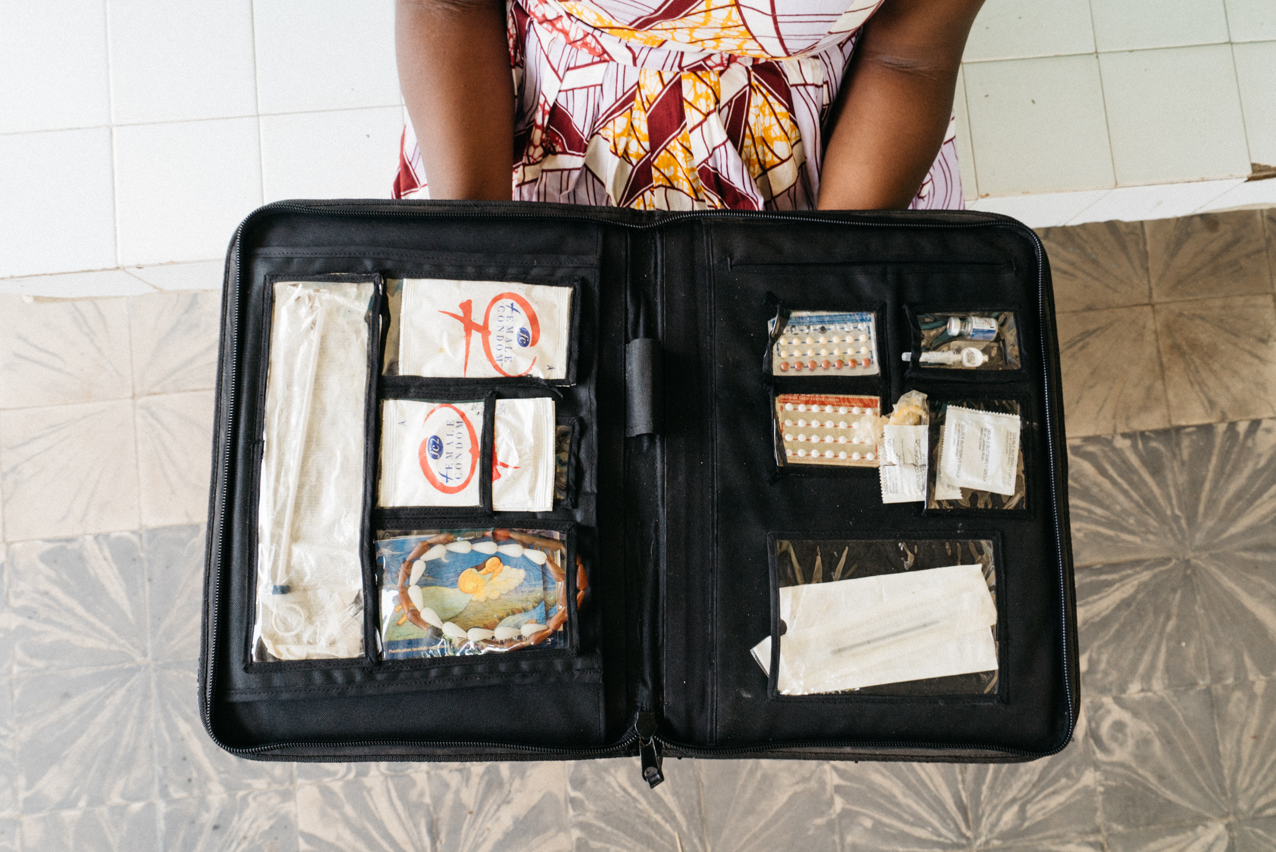A woman holds a family planning display case containing a mix of contraception options. © 2016 PATH/Gabe Bienczycki, Courtesy of Photoshare