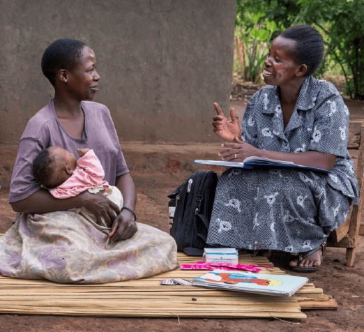 Women talk while one holds a baby.